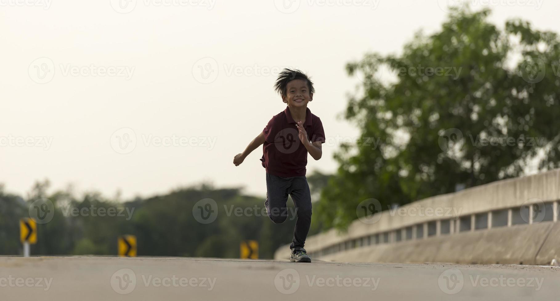 un niño pequeño corre a lo largo del puente. foto