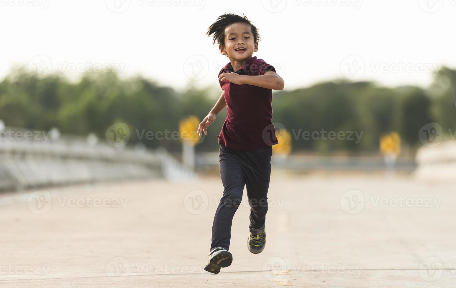 A little boy runs along the bridge. photo