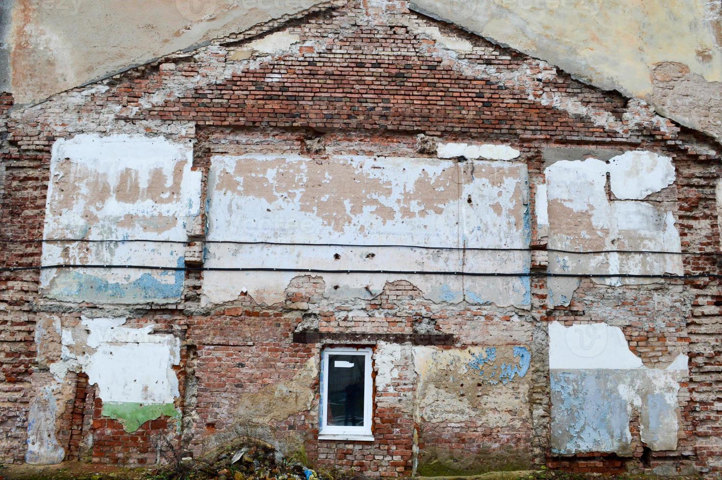 A trail from the ruined building on a brick wall. Imprint of the old demolished building on the wall of another house. photo