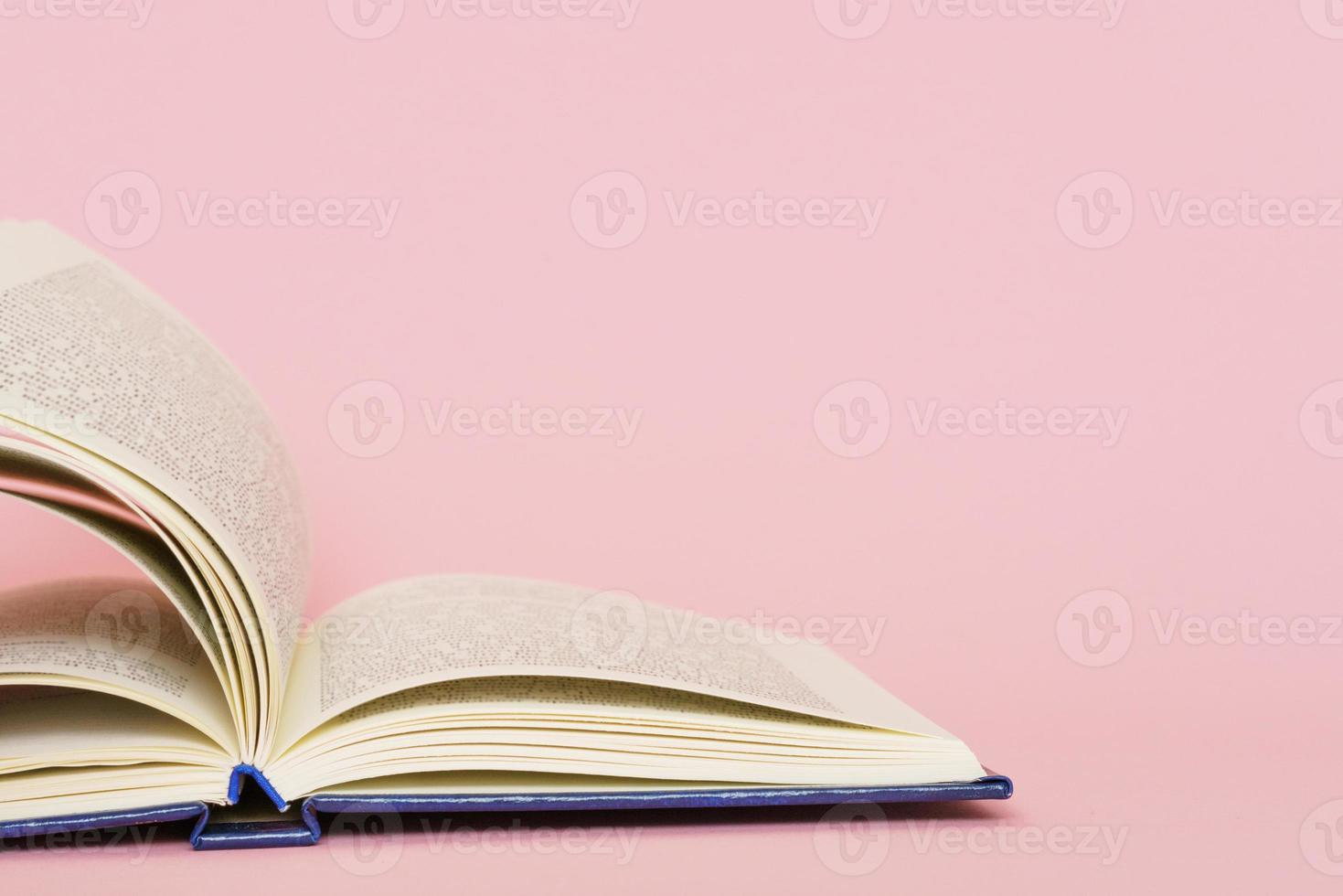 Open book page closeup on pink background, back to school education concept. photo