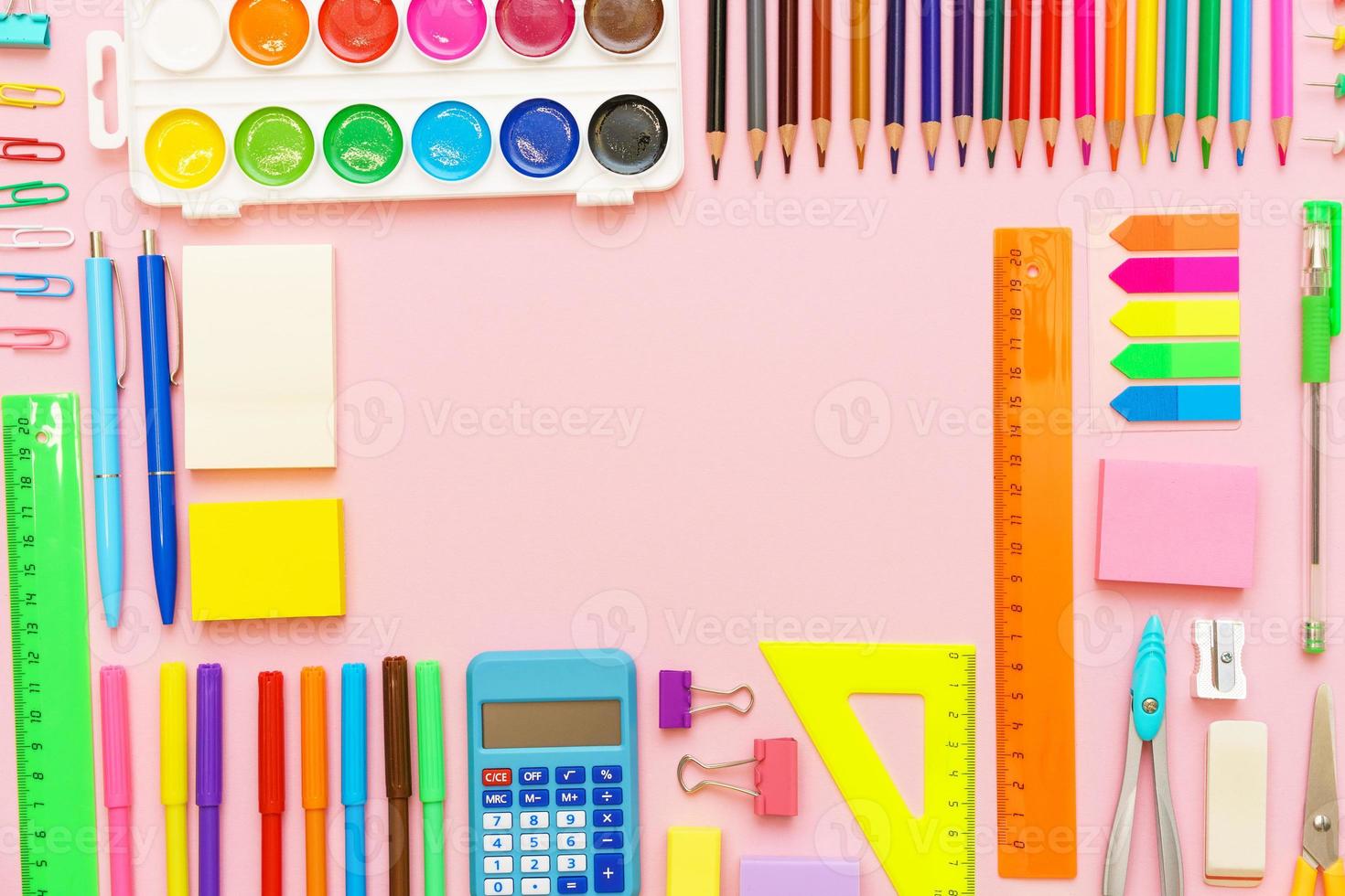 School stationery colorful paint pencils and pens on pink background in form photo