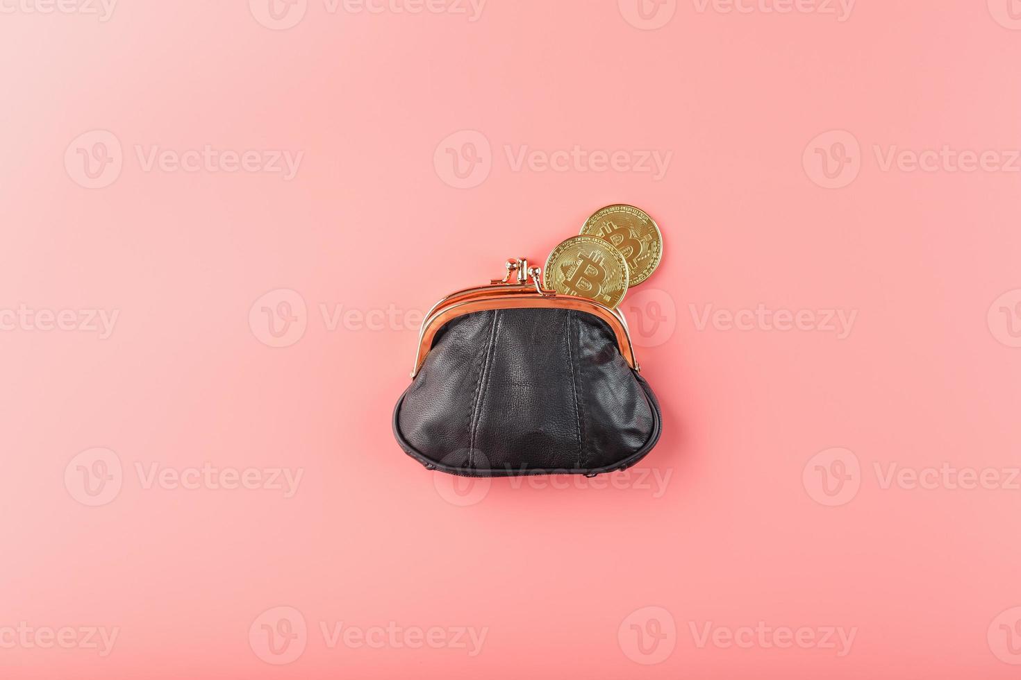 Classic black wallet with bitcoin coins on a pink background. photo