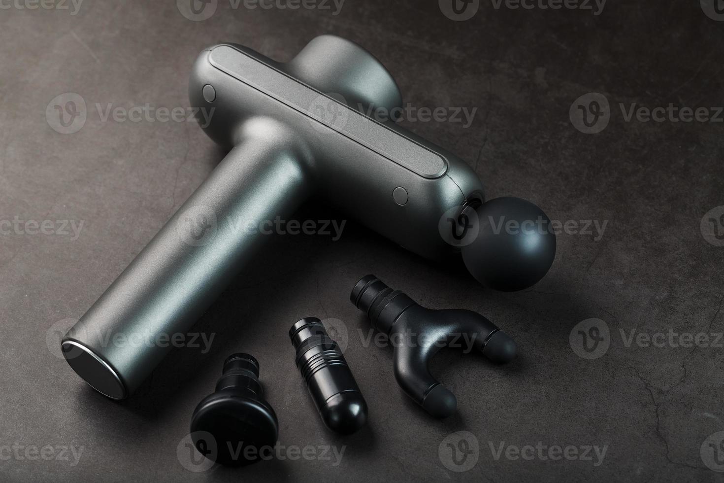 Electric massager for body massage on a black background. Universal device for improving the whole body photo