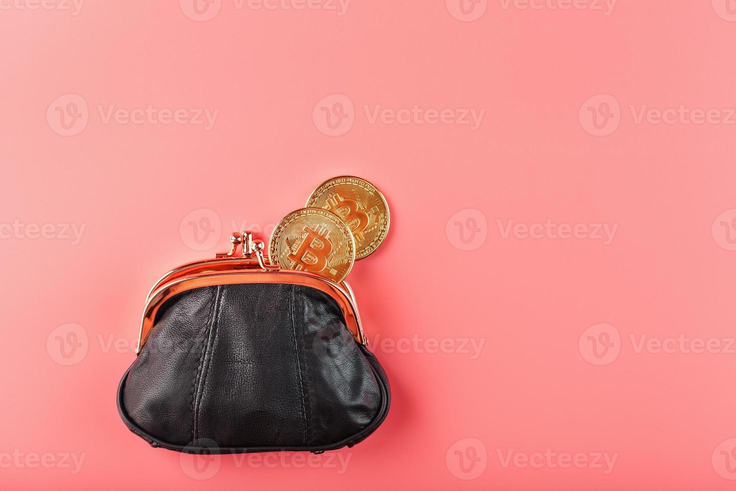 Classic black wallet with bitcoin coins on a pink background. photo