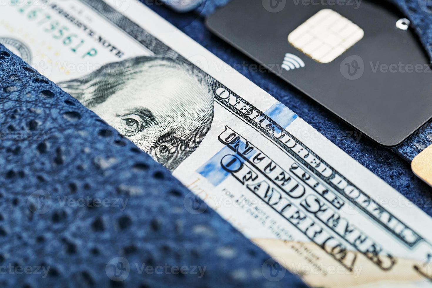 Blue purse with banknotes and credit cards on a black background. photo