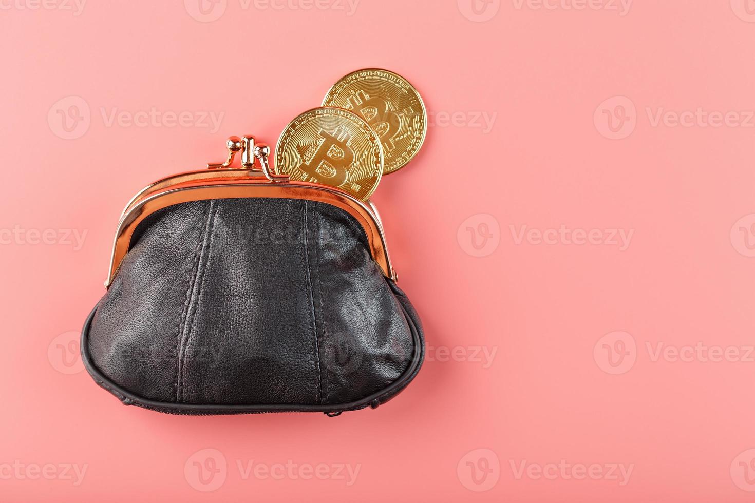 Classic black wallet with bitcoin coins on a pink background. photo