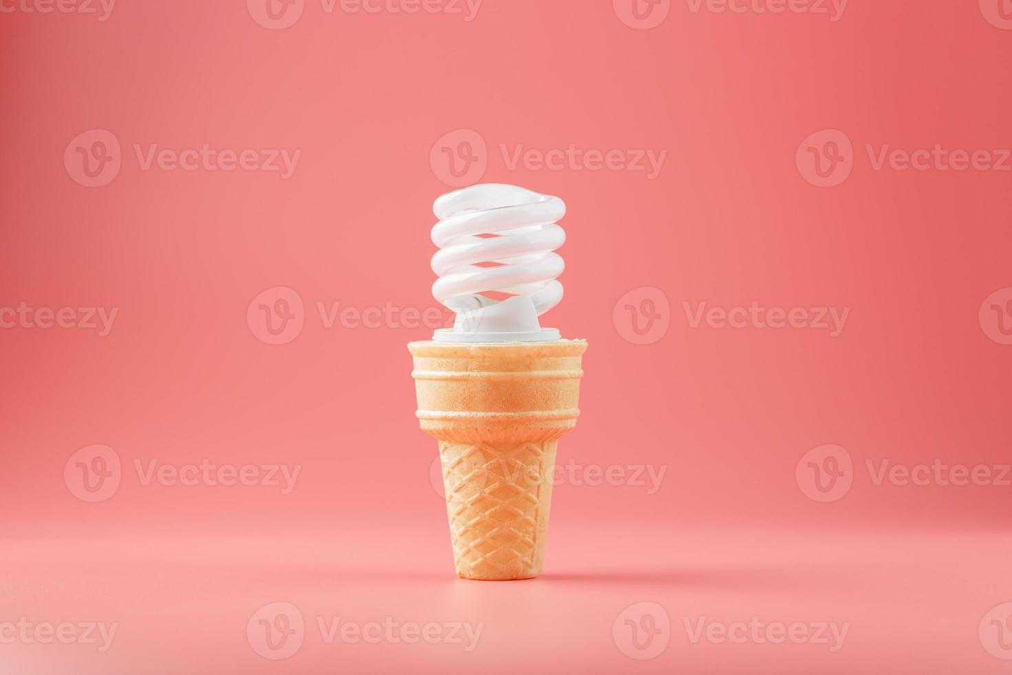 Energy-saving screw Light ice cream in a waffle cone on a pink background. photo