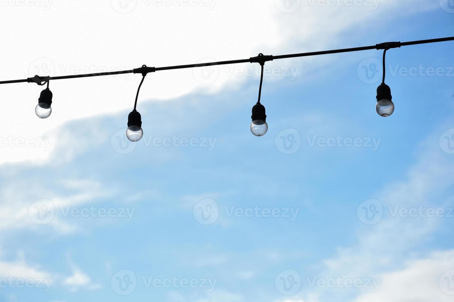 Wire of lignting bulbs tied around the outdoor area of the house to decorate and to celebrate the special events, soft and selective focus. photo