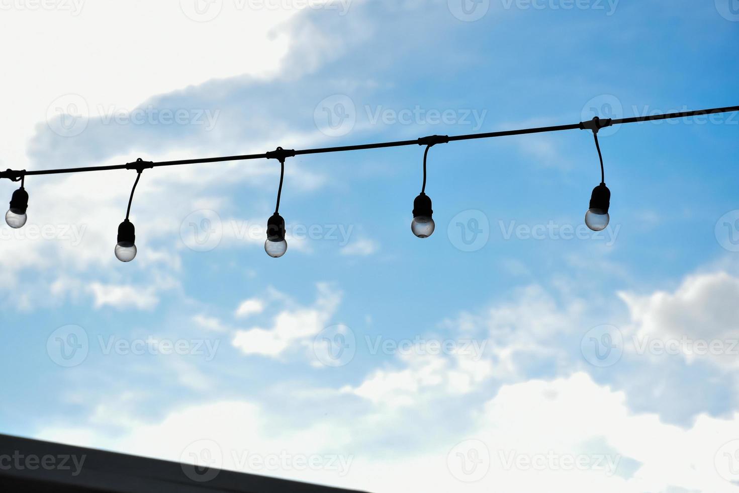 Wire of lignting bulbs tied around the outdoor area of the house to decorate and to celebrate the special events, soft and selective focus. photo