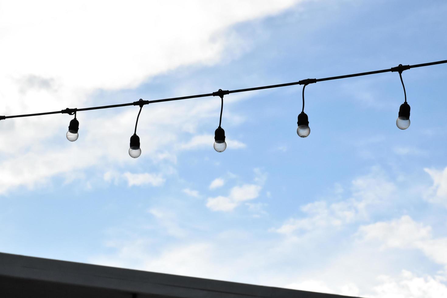 Wire of lignting bulbs tied around the outdoor area of the house to decorate and to celebrate the special events, soft and selective focus. photo