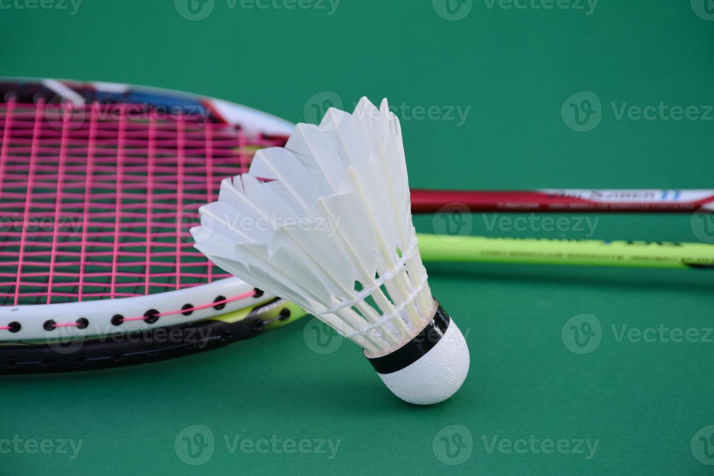 Cream white badminton shuttlecock and racket on floor in indoor badminton court, copy space, soft and selective focus on shuttlecocks. photo