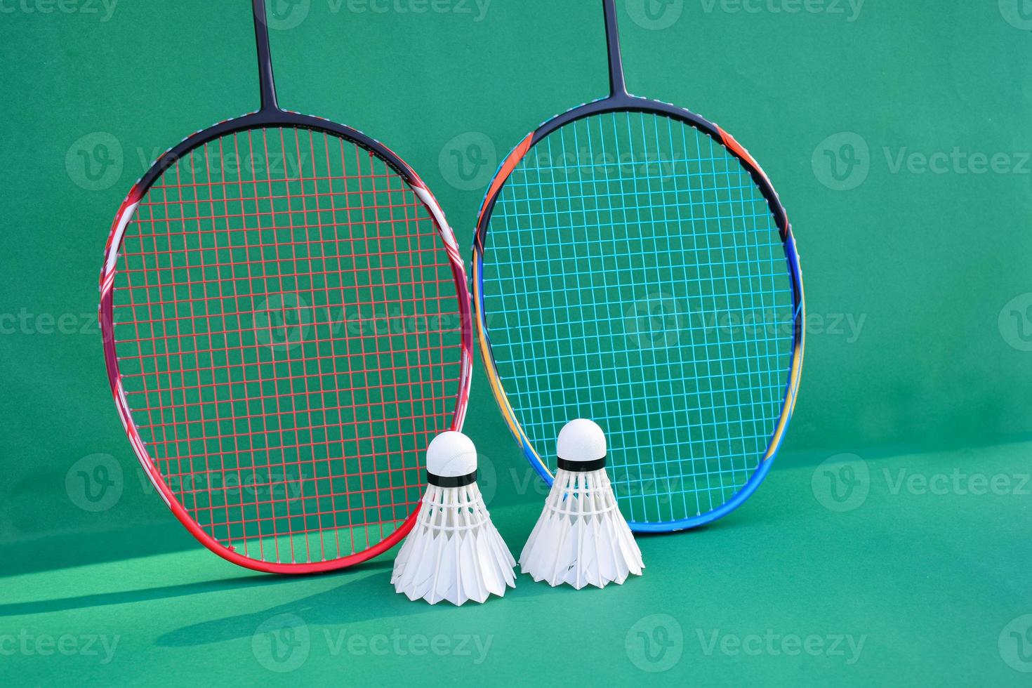 Cream white badminton shuttlecock and racket on floor in indoor badminton court, copy space, soft and selective focus on shuttlecocks. photo