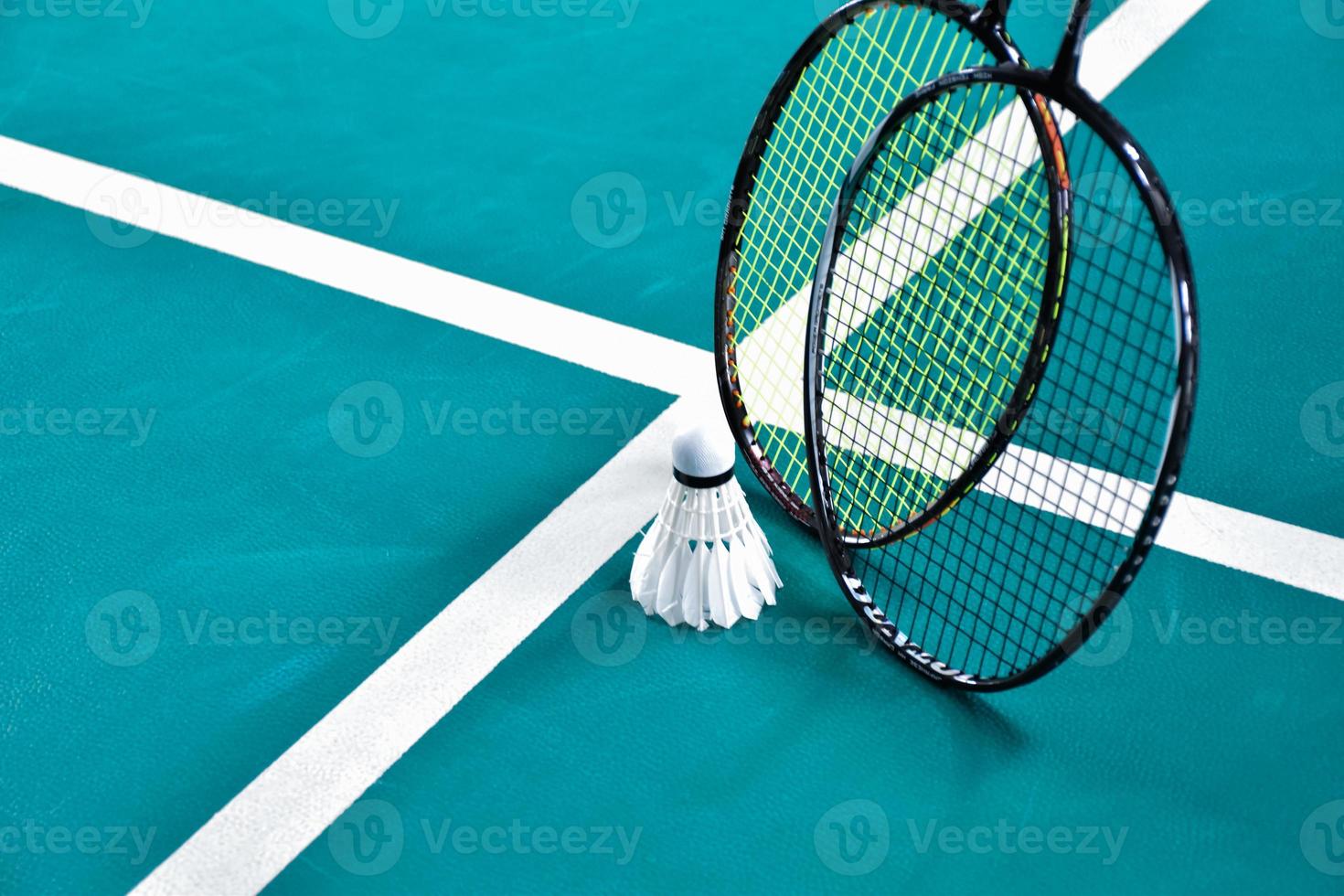 Cream white badminton shuttlecock and racket on floor in indoor badminton court, copy space, soft and selective focus on shuttlecocks. photo