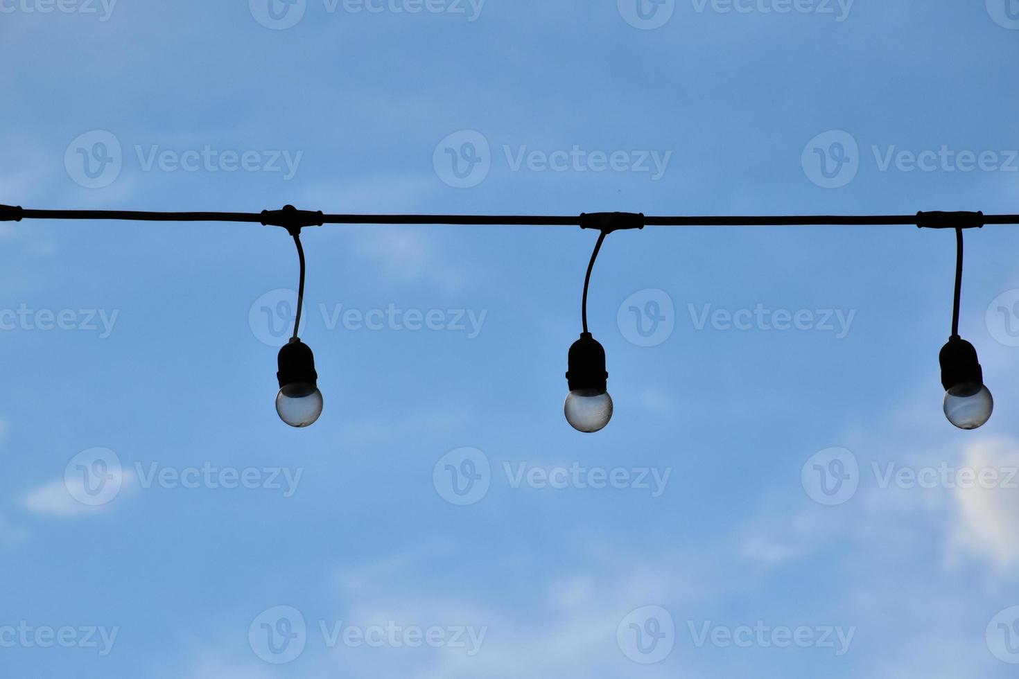 Wire of lignting bulbs tied around the outdoor area of the house to decorate and to celebrate the special events, soft and selective focus. photo