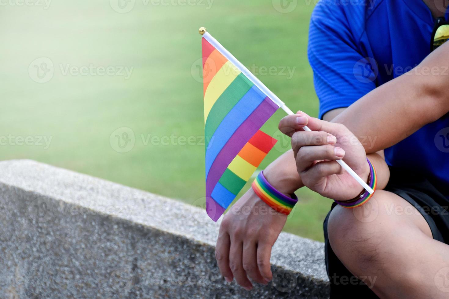 Rainbow flag and wristbands holding in hands, soft and selective focus, concept for lgbtq genders celebrations and calling all people to respect human rights in pride month around the world. photo