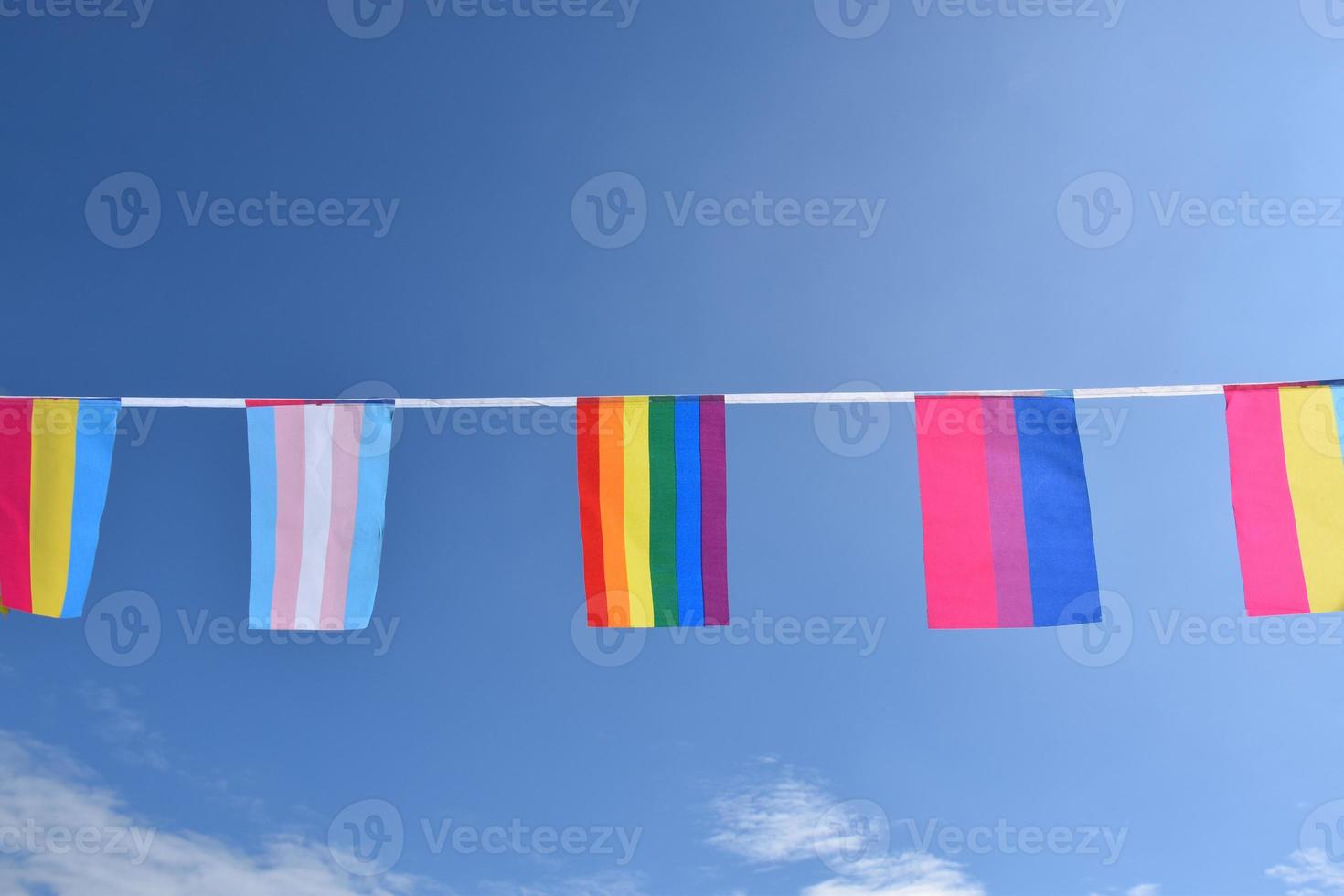 Las banderas lgbtq se colgaron en un cable contra el cielo azul en un día soleado, enfoque suave y selectivo, concepto para celebraciones de género lgbtq en el mes del orgullo en todo el mundo. foto