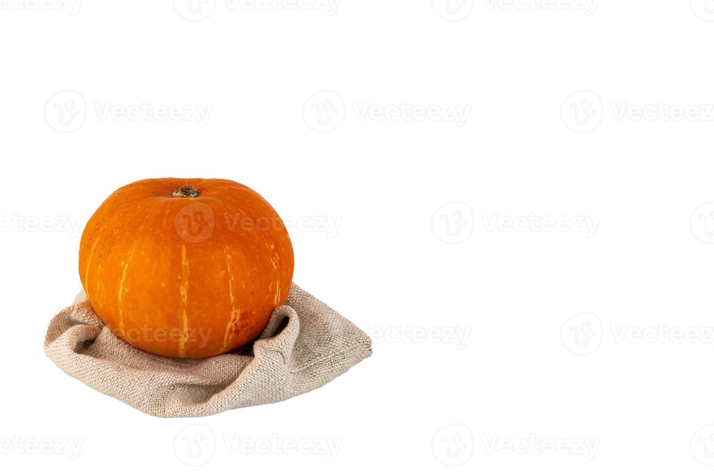 Round orange pumpkin on a linen bag white isolated background. photo