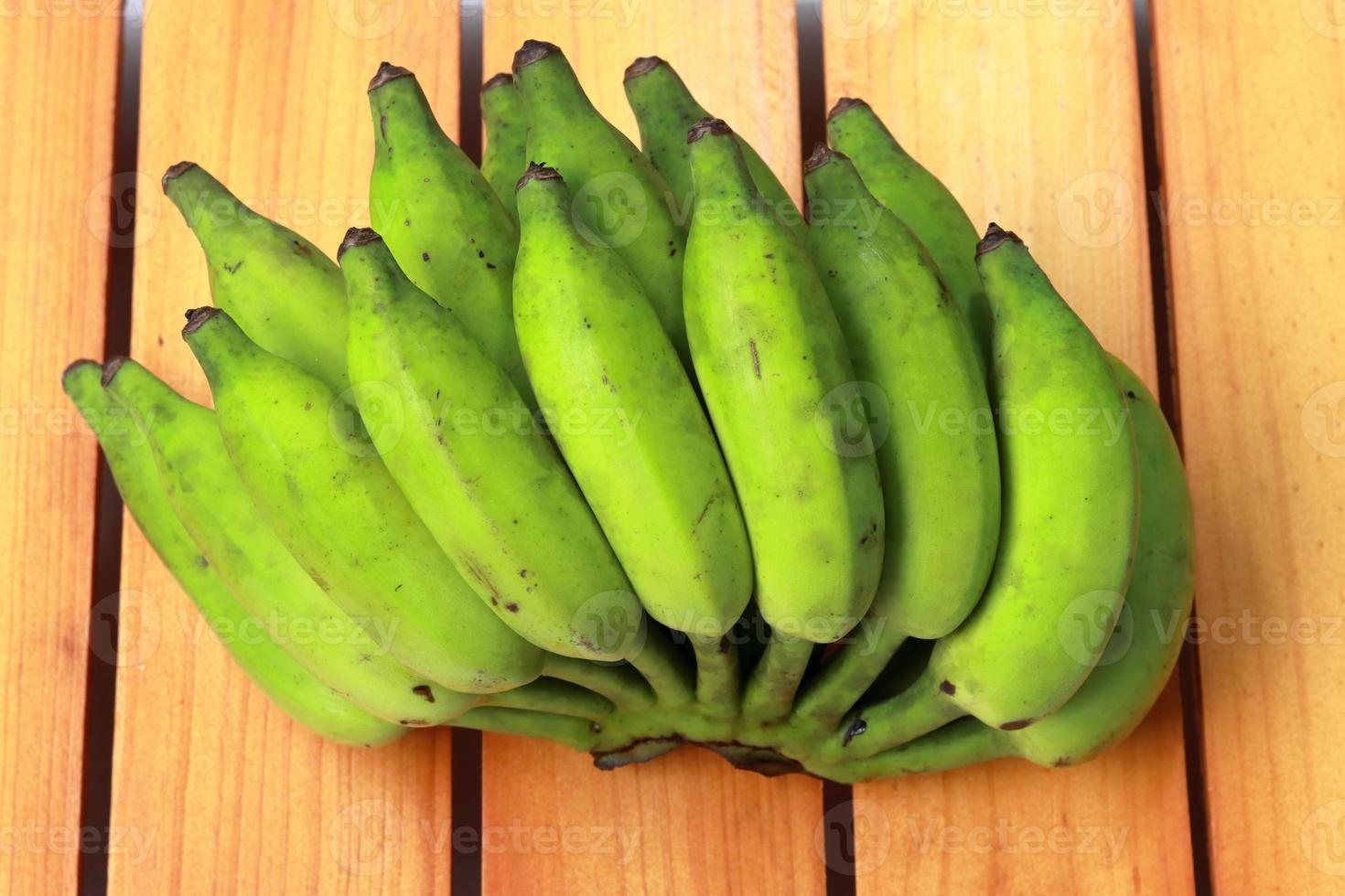 Banana on wooden background. Healthful red banana collection. Ripe bunch of banana photo