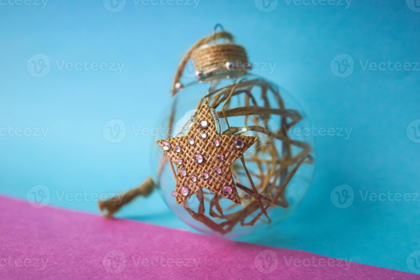 Small round glass transparent vintage homemade smart hipster decorative beautiful Christmas festive Christmas ball, Christmas tree toy with hay, straw inside and with a star photo