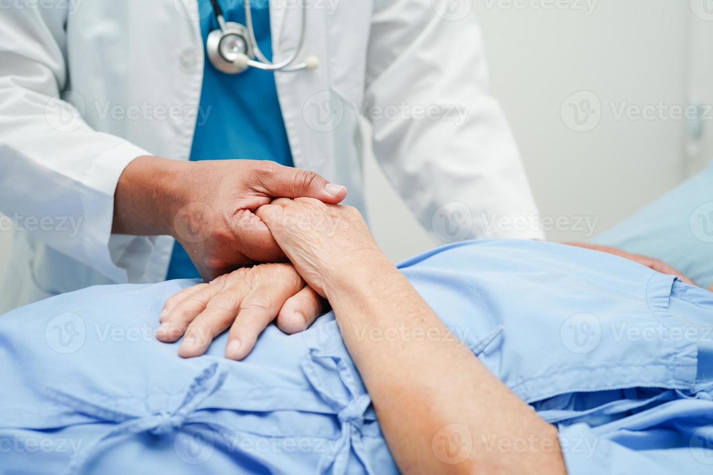 Doctor holding hands Asian elderly woman patient, help and care in hospital. photo