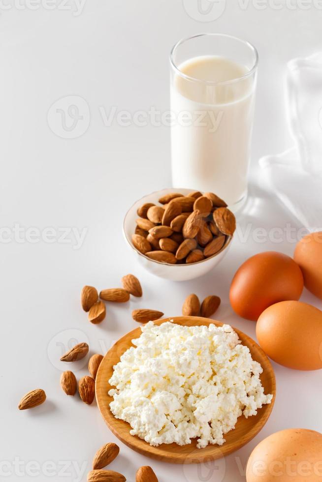 Protein food on a white background - cottage cheese, eggs, nuts. A set of healthy foods for a balanced diet. photo