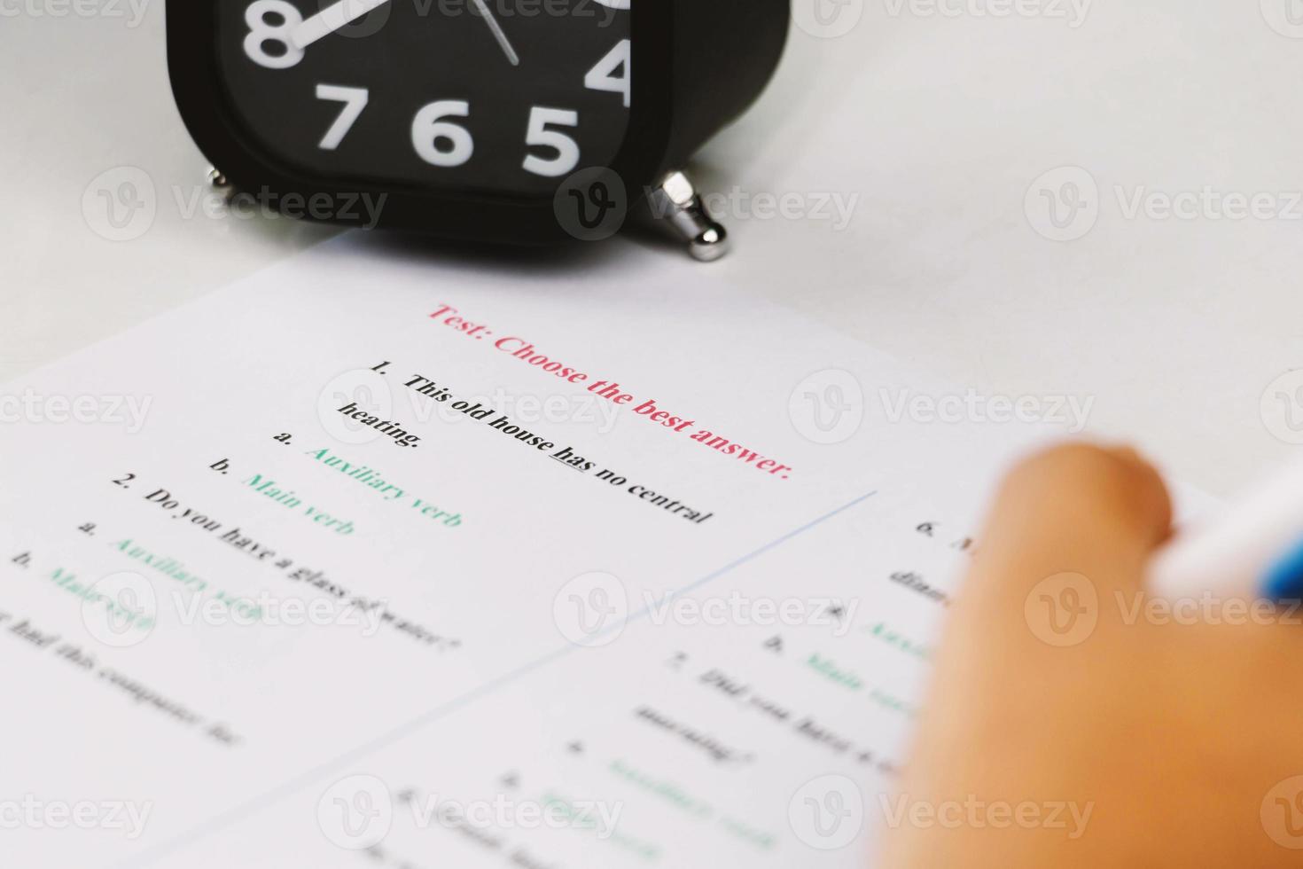 mano de estudiante tomando examen de inglés en clase foto