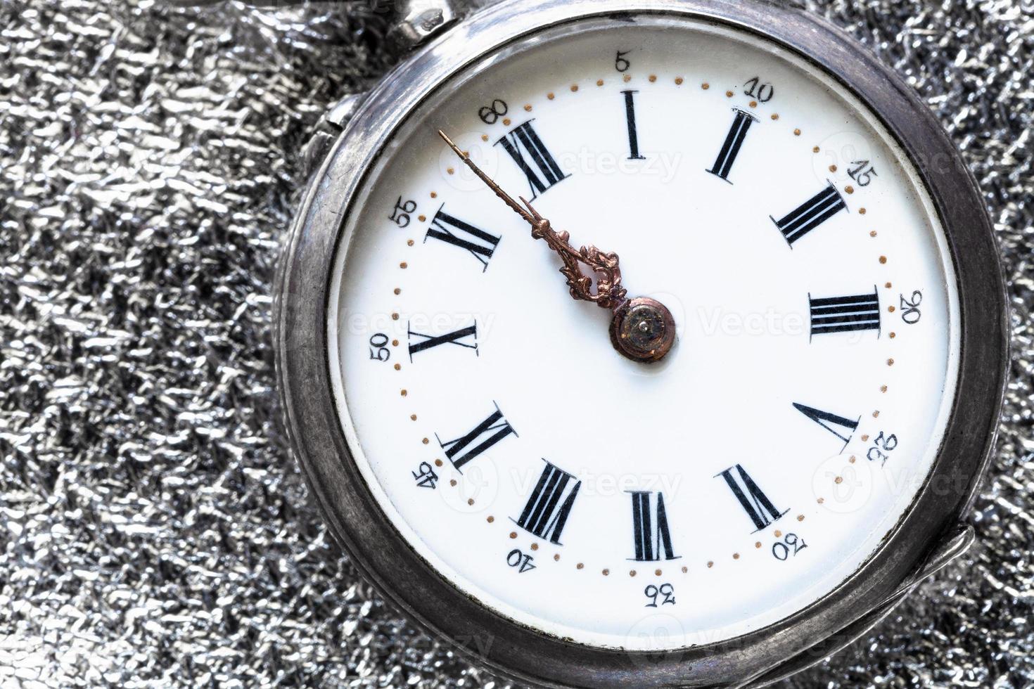 retro pocket watch on silver cloth close up photo