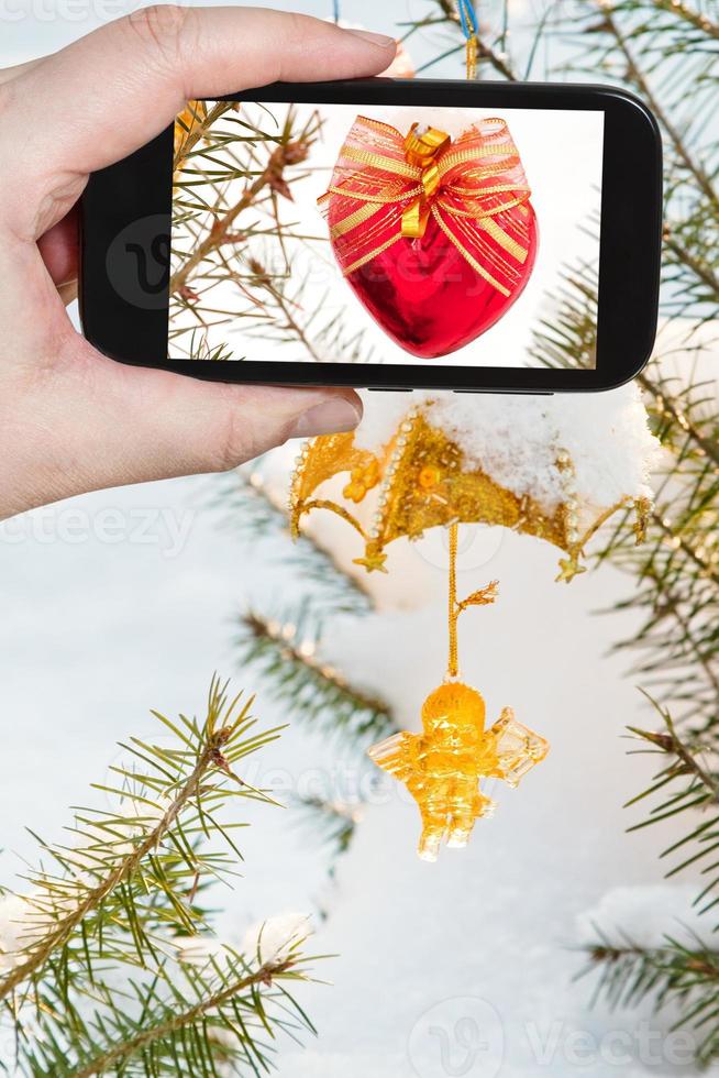 tomando fotos de la decoración del árbol de navidad al aire libre