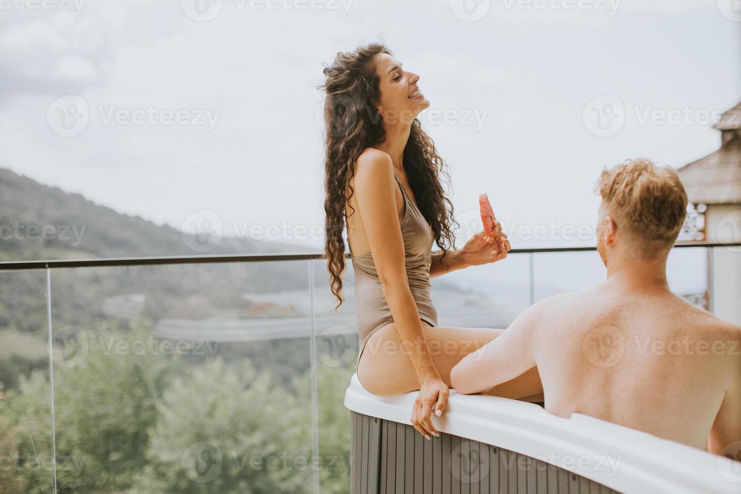 pareja joven disfrutando en el jacuzzi al aire libre de vacaciones foto