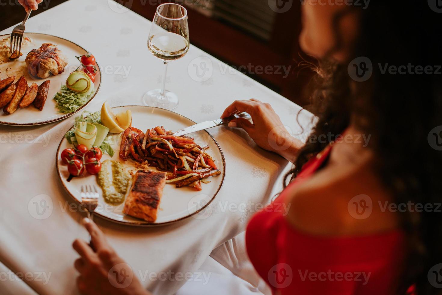 pareja joven almorzando con vino blanco en el restaurante foto