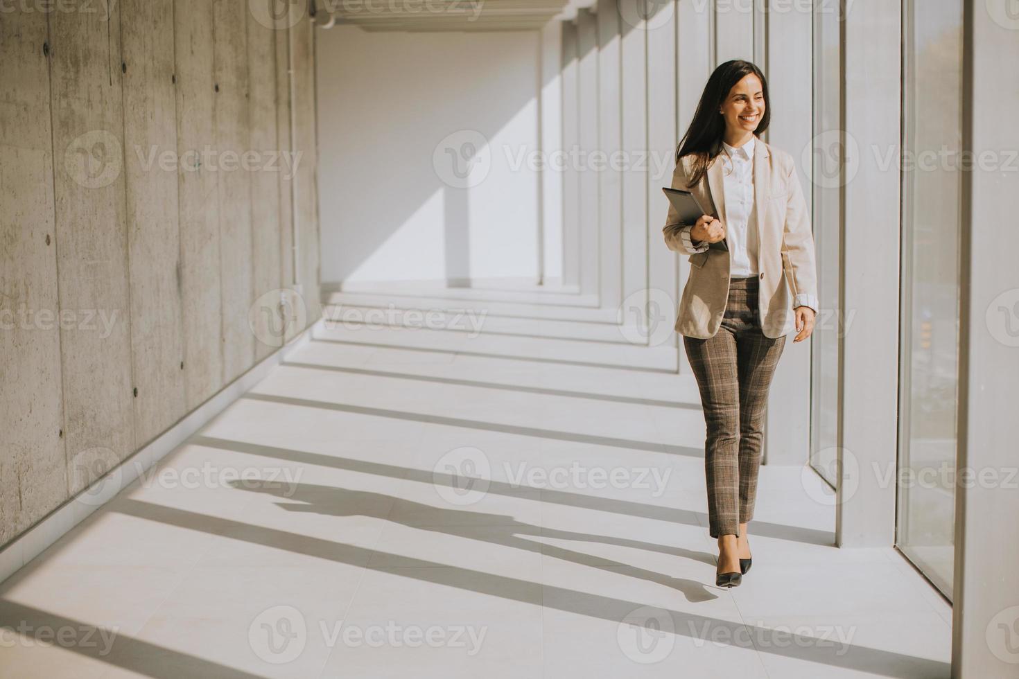 joven empresaria caminando en el pasillo de la oficina moderna foto