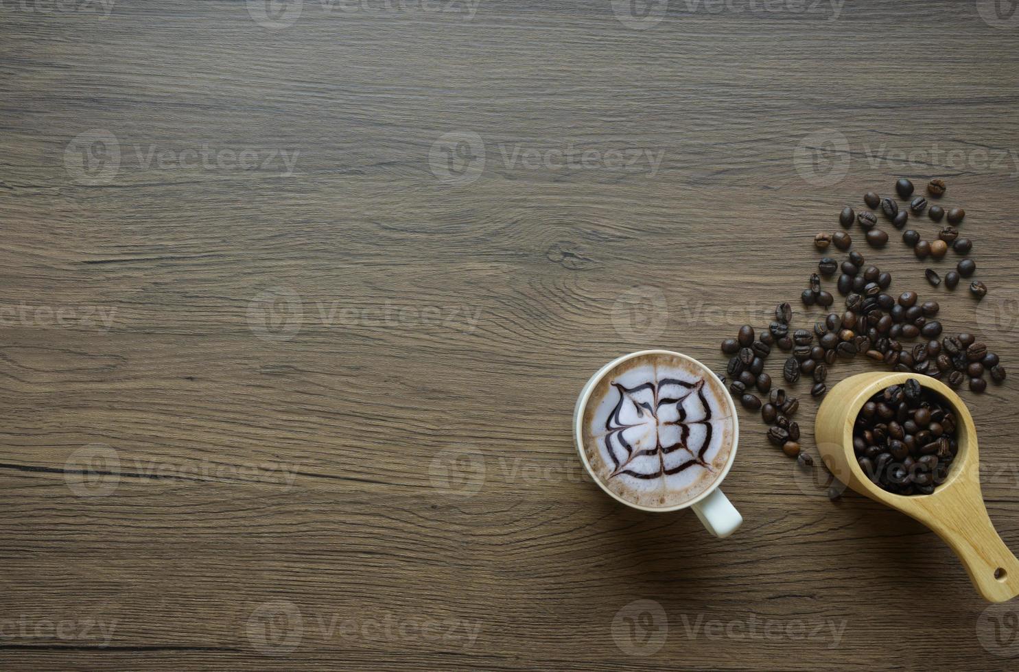 Coffee in a mug with wood grain screen and coffee beans in a spoon photo