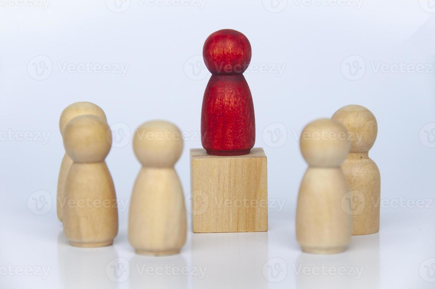 Red wooden people figure on top of wooden cube leading the rest of the followers. Leadership concept. photo