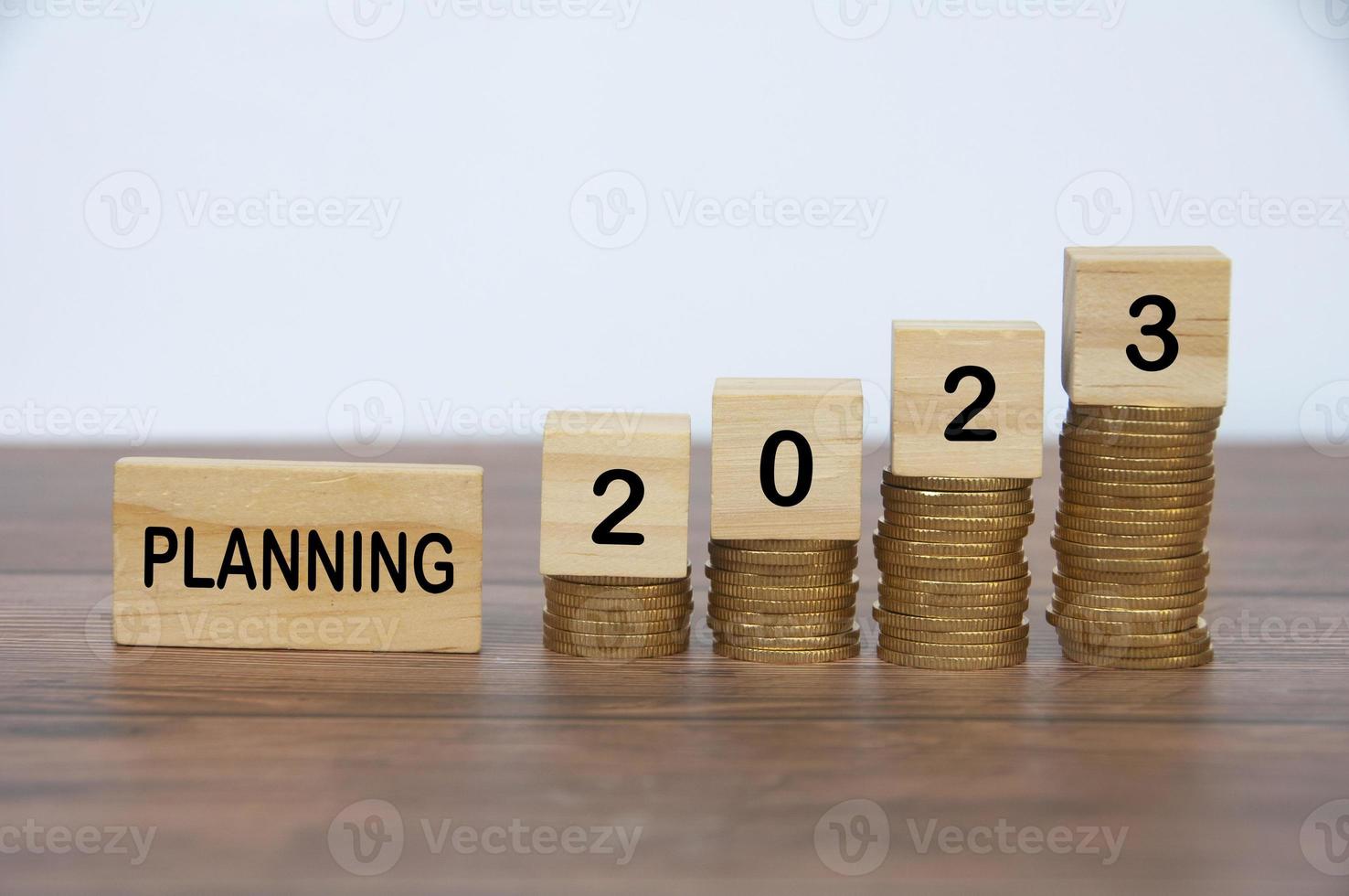 Planning 2023 text on wooden blocks with golden coins background. Business and new year planning concept. photo