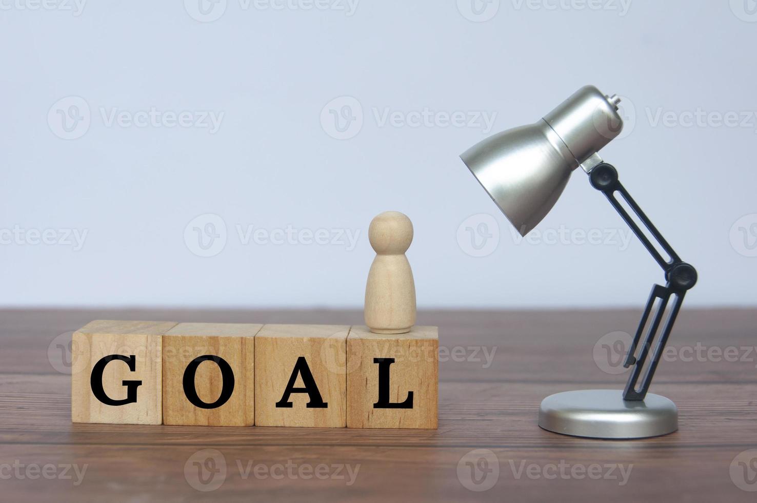 Goal text on wooden cubes with table lamp background. Goal setting and business concept. photo