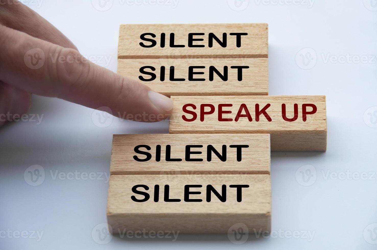 Finger pointing at wooden block with word speak up. Courage to speak up concept photo