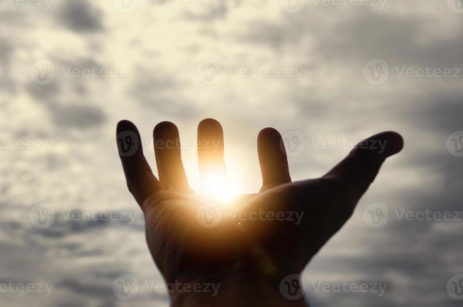 Light shining on hand with vintage sky color background. Copy space. photo