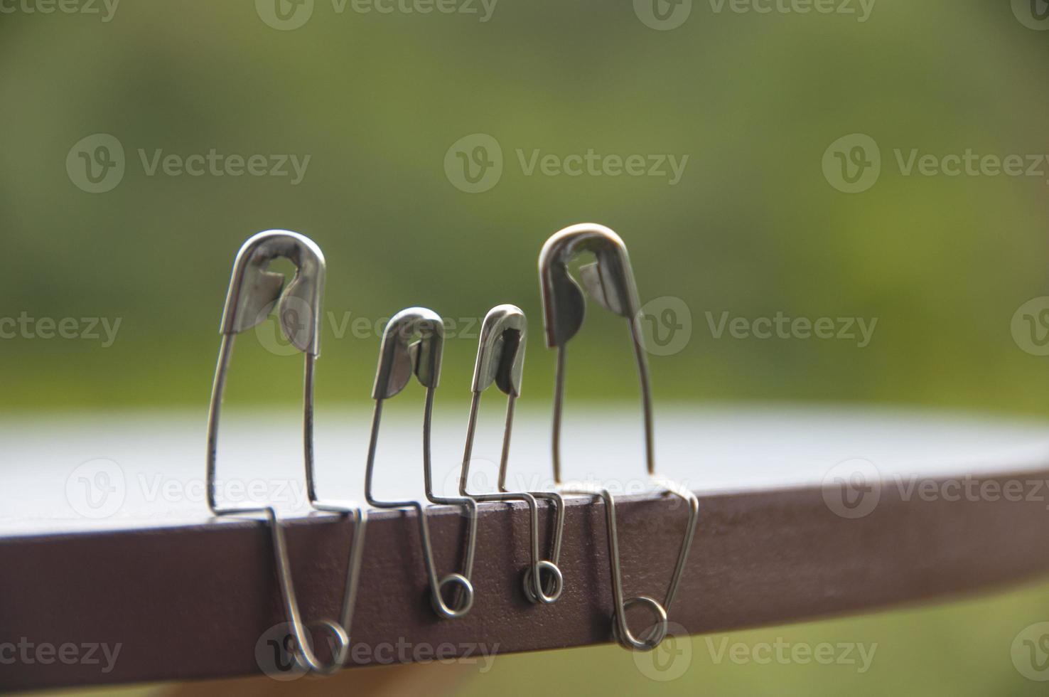 Model safety pin of family sitting on wooden table with blurred nature background. Copy space and family concept photo