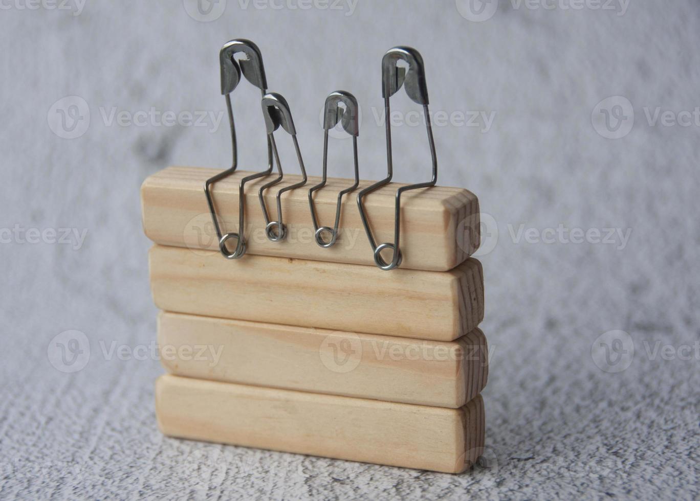 Model safety pin of family sitting on wooden blocks with customizable space for text. Family concept photo