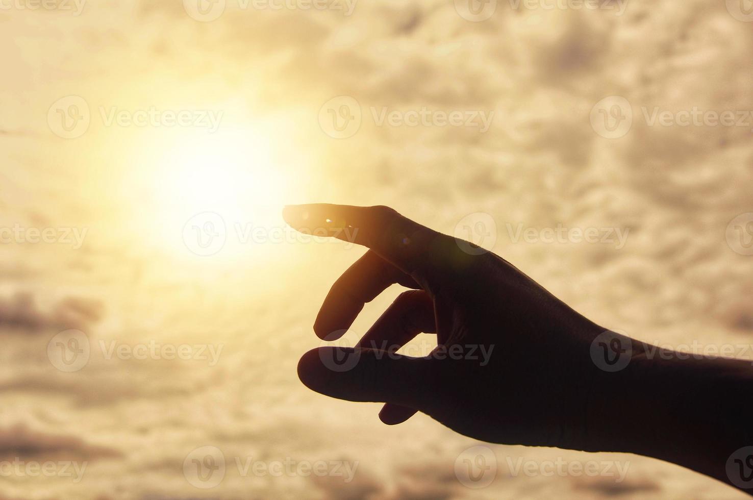 Hand reaching out to bright shining light. photo