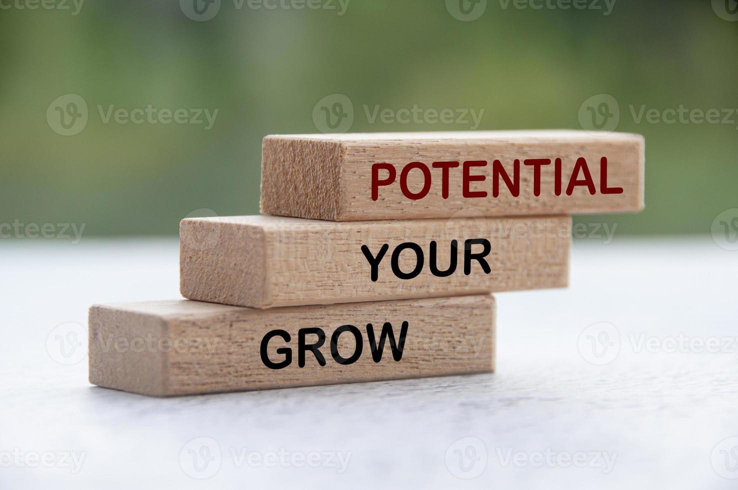 Grow your potential text on stacked wooden blocks with blurred nature background. Motivational concept photo