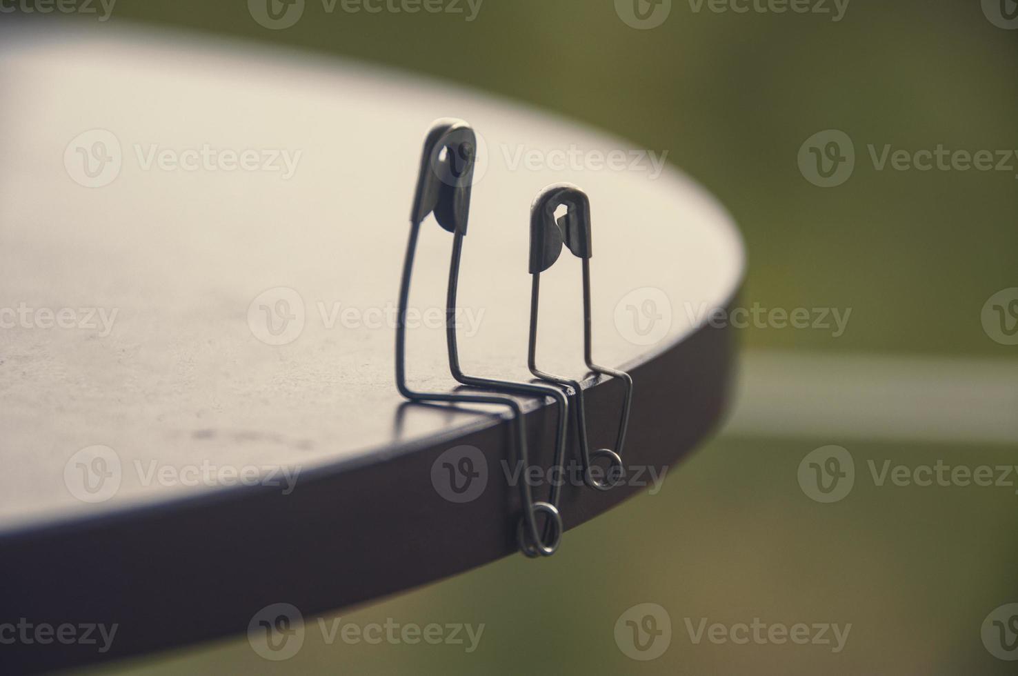 Model safety pin of father or mother and son or daughter sitting on wooden blocks. Family concept photo