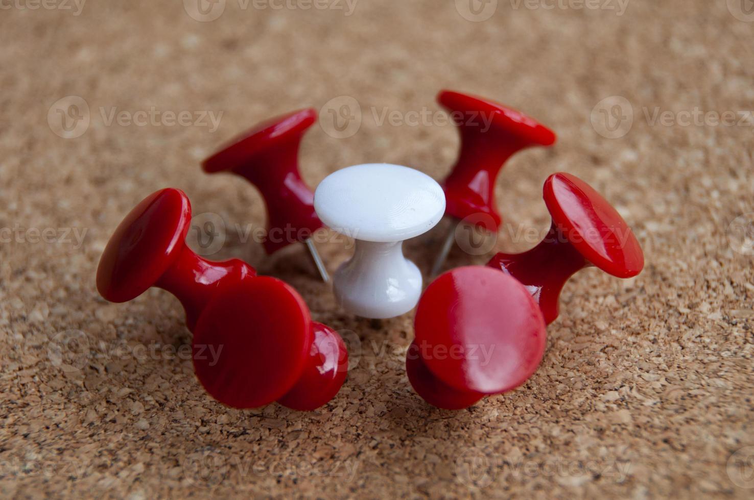 White push pin surrounded by red push pins. Harassment and discrimination concept photo
