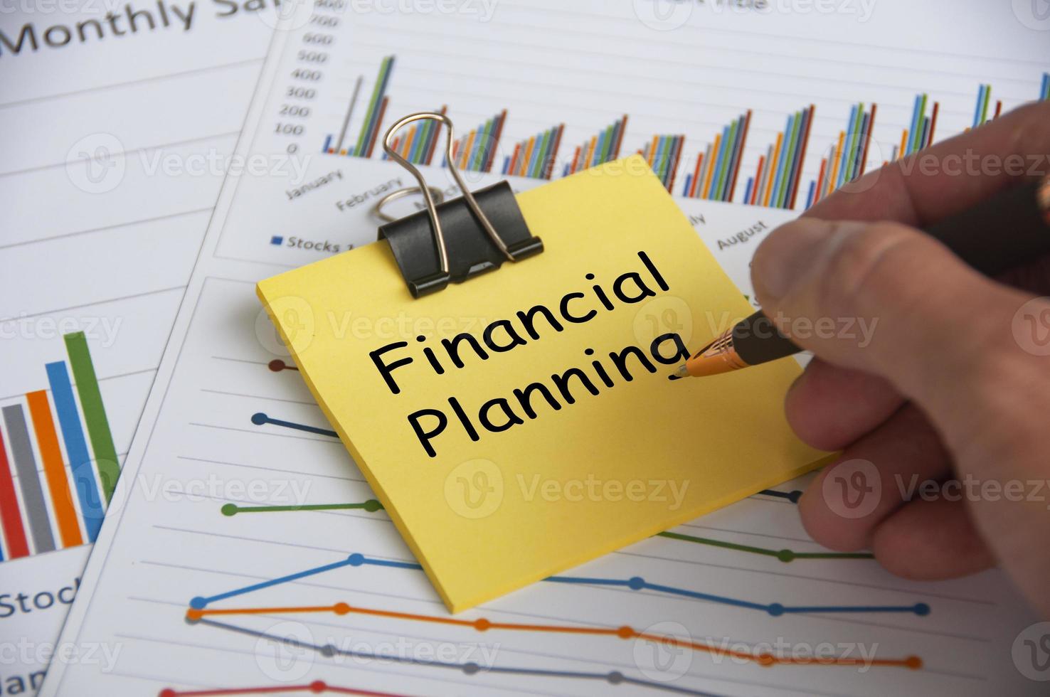 Financial planning text on yellow notepad with financial data analysis background. Financial planning concept. photo