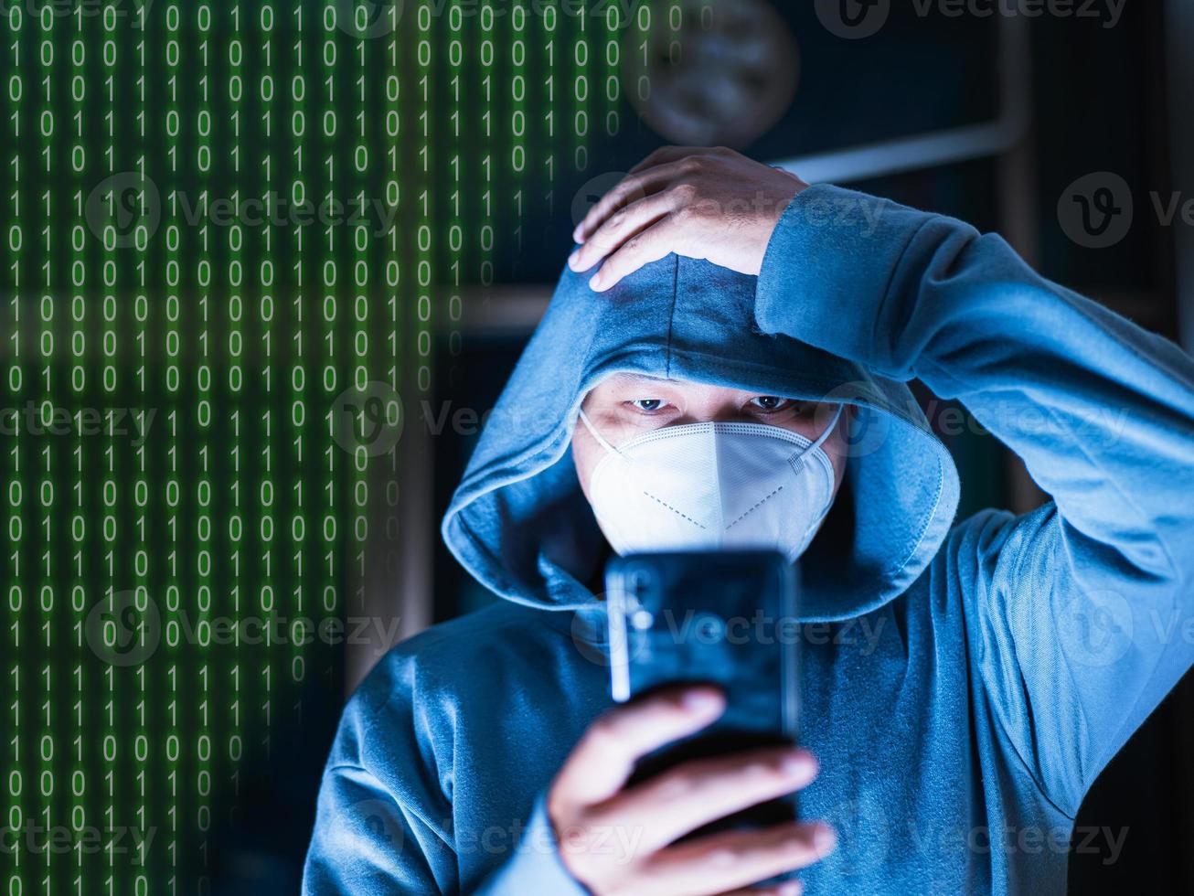 Asian man in hoodie and mask hacking Something from a mobile phone intended for blurry photos has digital numbers. number one with zero