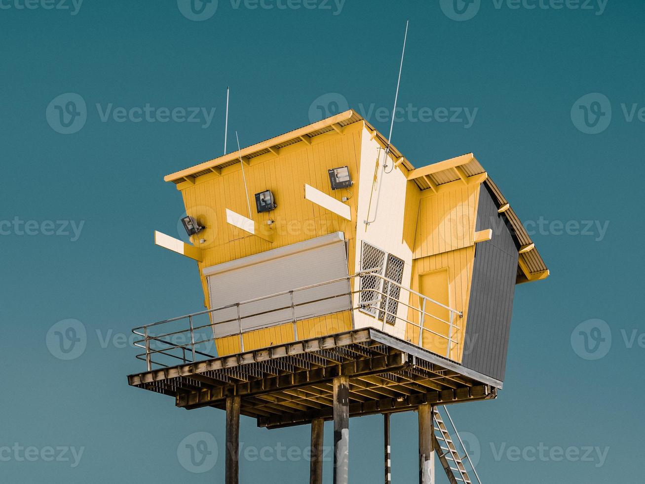 Profile view of a lifeguard watch tower against blue sky photo