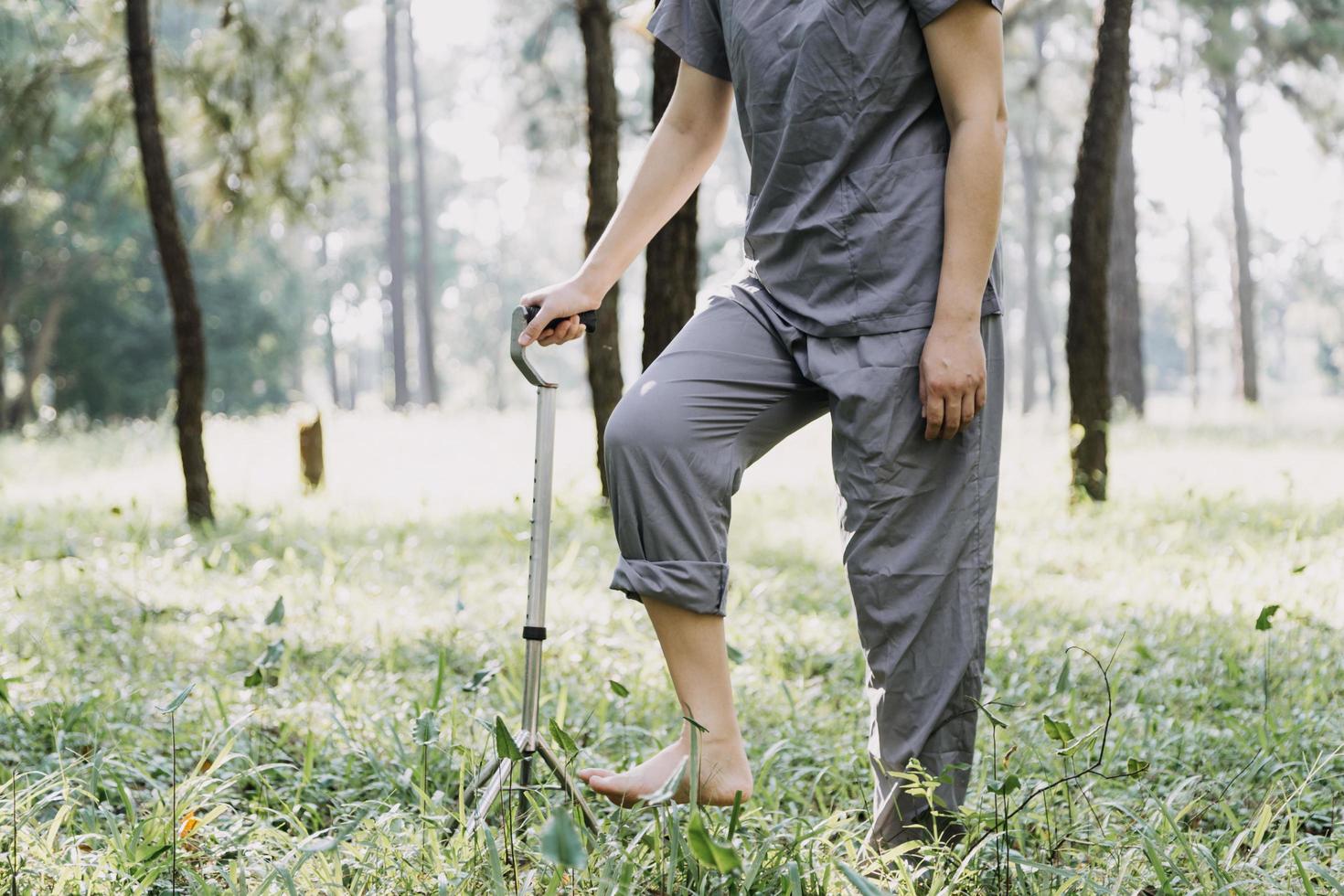 young asian physical therapist working with senior woman on walking with a walker photo