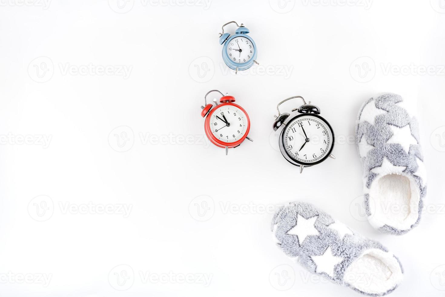 Soft fluffy slippers and alarm clocks photo