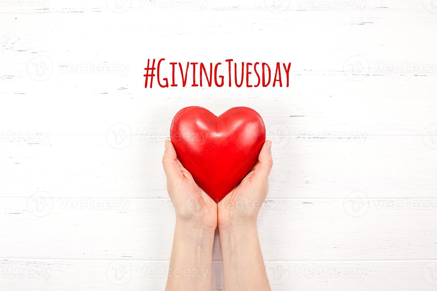 Giving Tuesday concept with red heart in hands photo