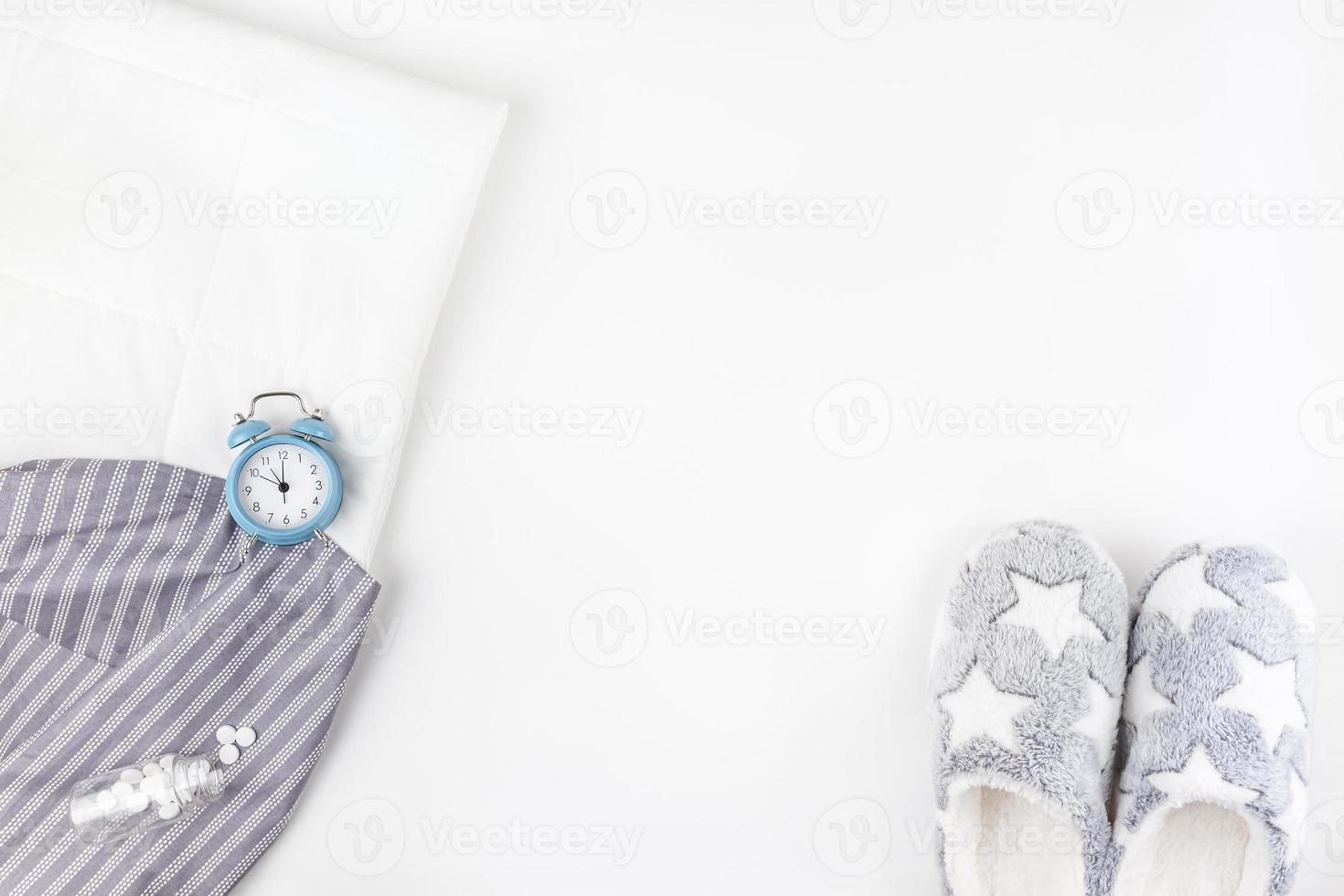 Soft fluffy slippers and blue alarm clock photo